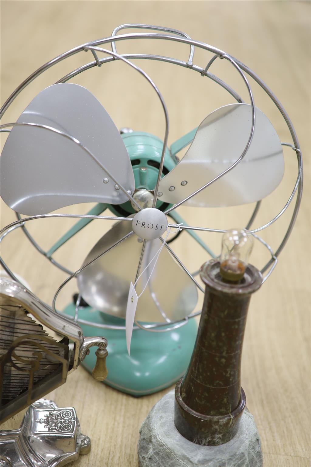 Early 20th century metal toaster and electric fan and lighthouse lamp and juicer